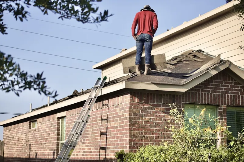 Professional roofer working on a residential roof in Darby